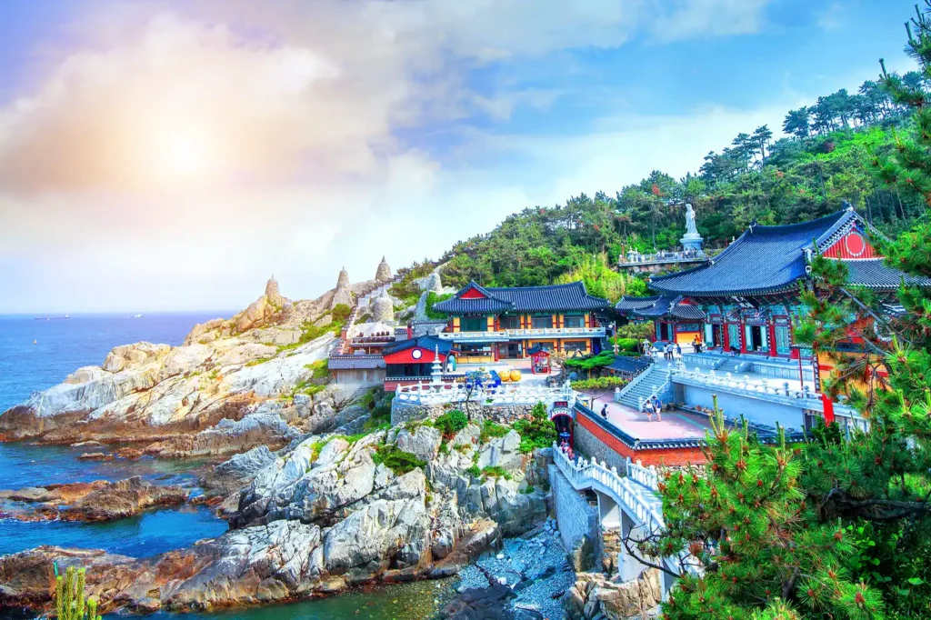 Vue du temple Haedong Yonggungsa à Busan, Corée du Sud, perché sur une falaise surplombant l'océan. Découvrez la majesté du temple Haedong Yonggungsa, un magnifique temple bouddhiste situé sur une falaise surplombant l'océan à Busan. Une visite incontournable lors de notre voyage en Corée du Sud avec Evans Becker. Pour en savoir plus, visitez Go Corée.