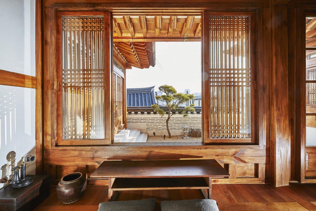 Salon traditionnel Hanok en bois à Jeonju, Corée du Sud, avec une décoration authentique et des éléments architecturaux coréens. Découvrez l'élégance d'un salon Hanok en bois à Jeonju, où l'architecture traditionnelle coréenne rencontre le confort moderne. Une immersion culturelle unique lors de notre voyage en Corée du Sud avec Evans Becker. Pour en savoir plus, visitez Go Corée.